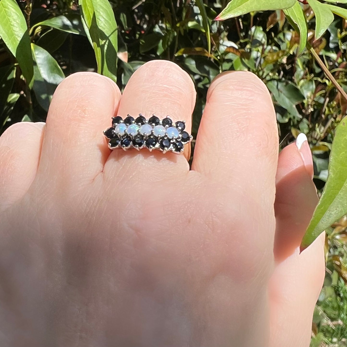 Gold ring with a band of opals surrounded by sapphires