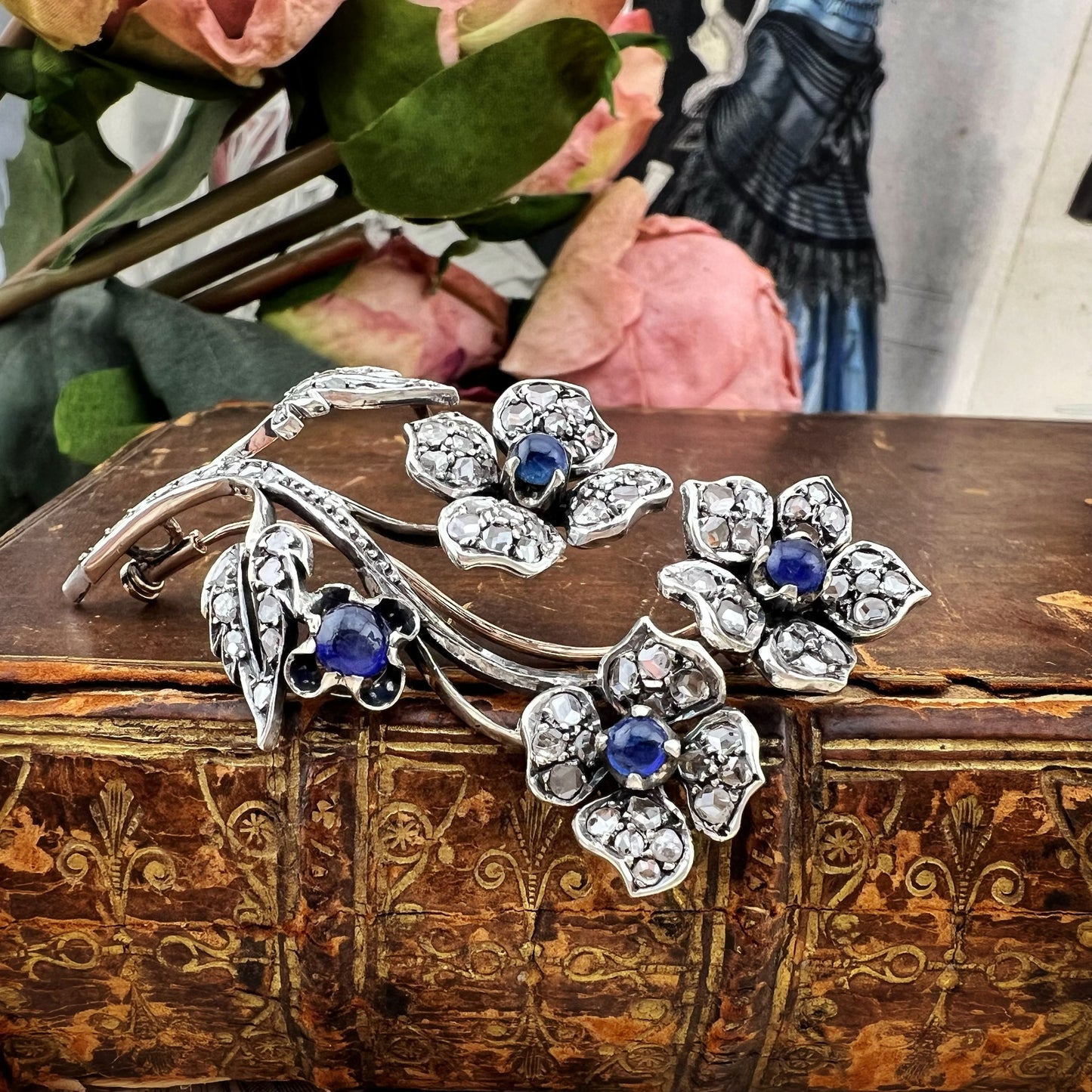 Spilla floreale in oro 18 kt, argento, zaffiri cabochon e diamanti