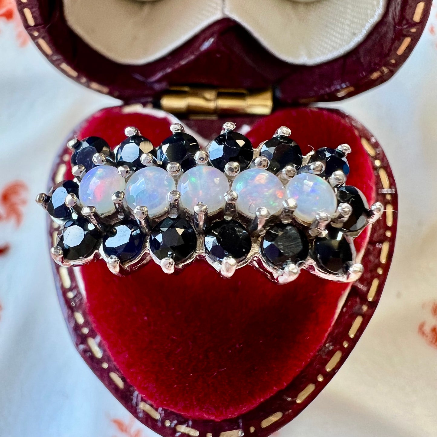 Gold ring with a band of opals surrounded by sapphires