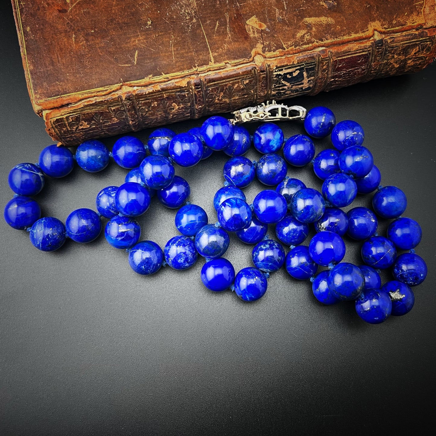 Necklace with natural lapis lazuli measuring 14 mm by 90 cm. Weight 242 grams. Clasp in gold, silver, diamonds and sapphires.