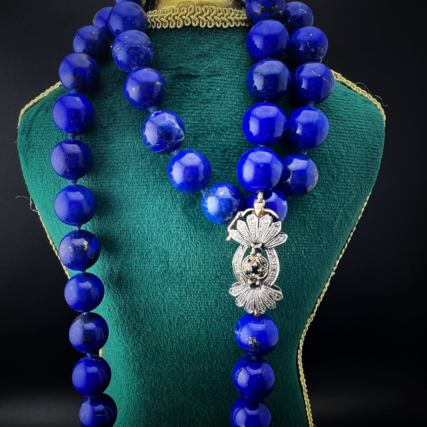 Necklace with natural lapis lazuli measuring 14 mm by 90 cm. Weight 242 grams. Clasp in gold, silver, diamonds and sapphires.