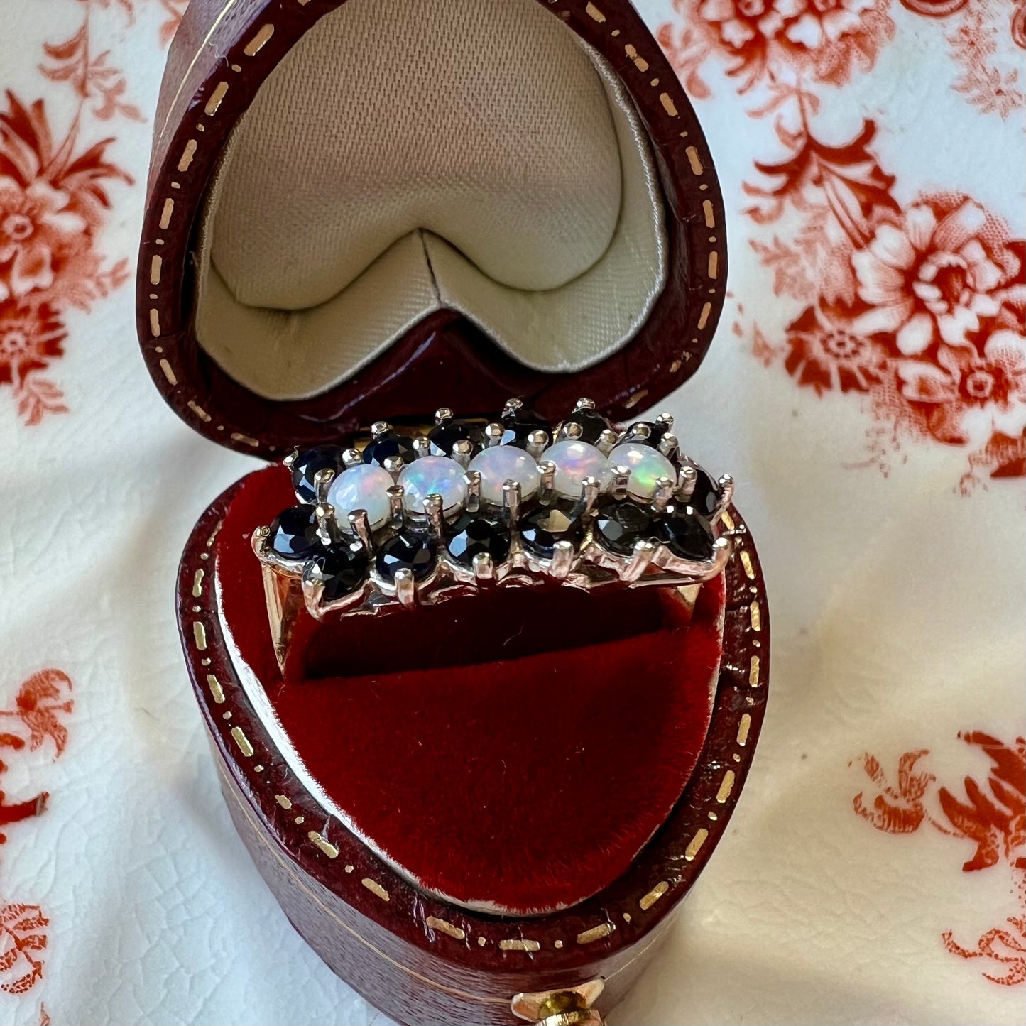 Gold ring with a band of opals surrounded by sapphires