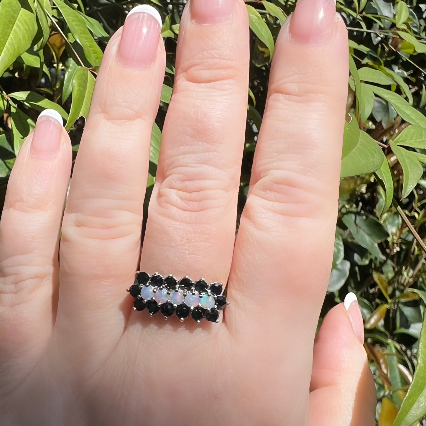 Gold ring with a band of opals surrounded by sapphires