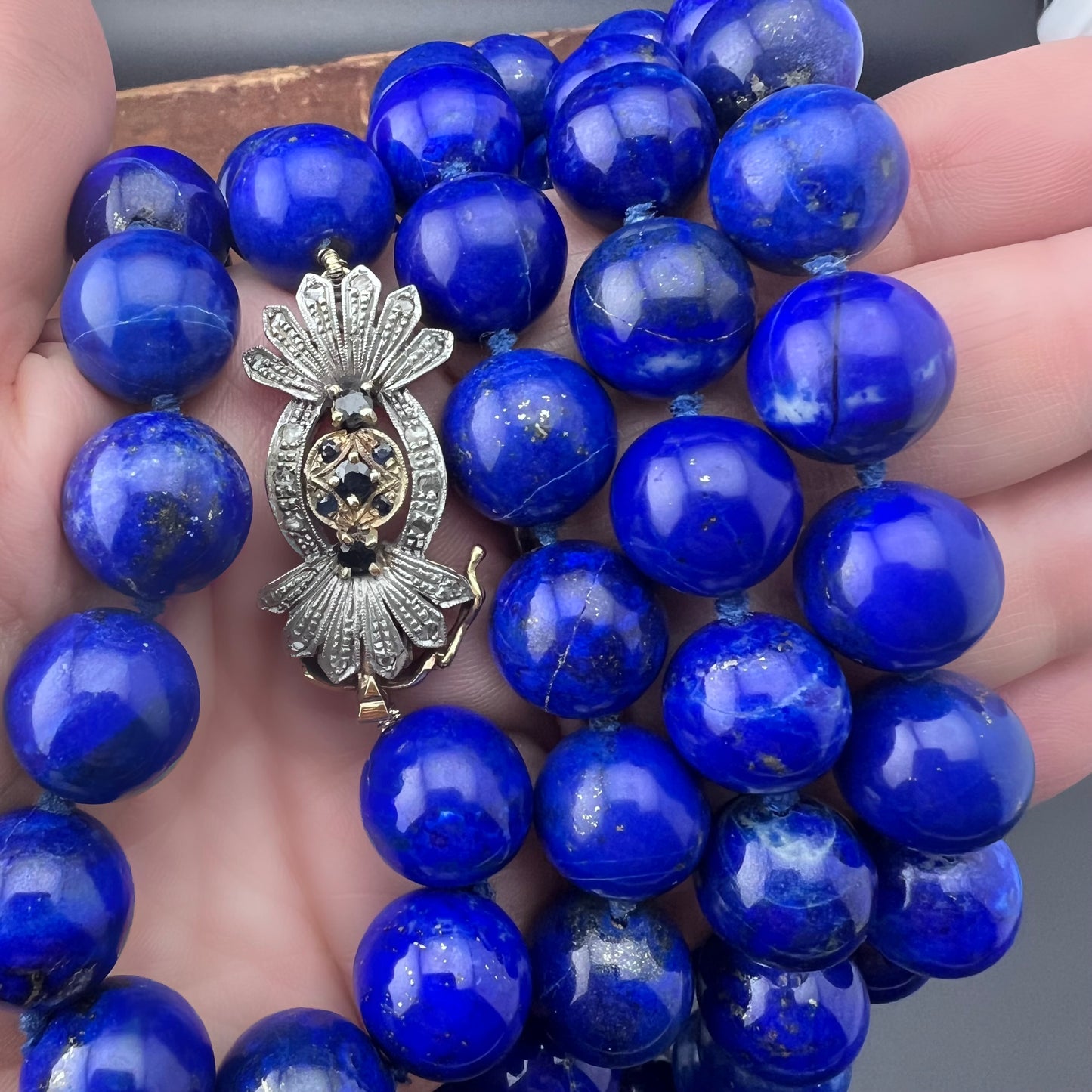 Necklace with natural lapis lazuli measuring 14 mm by 90 cm. Weight 242 grams. Clasp in gold, silver, diamonds and sapphires.