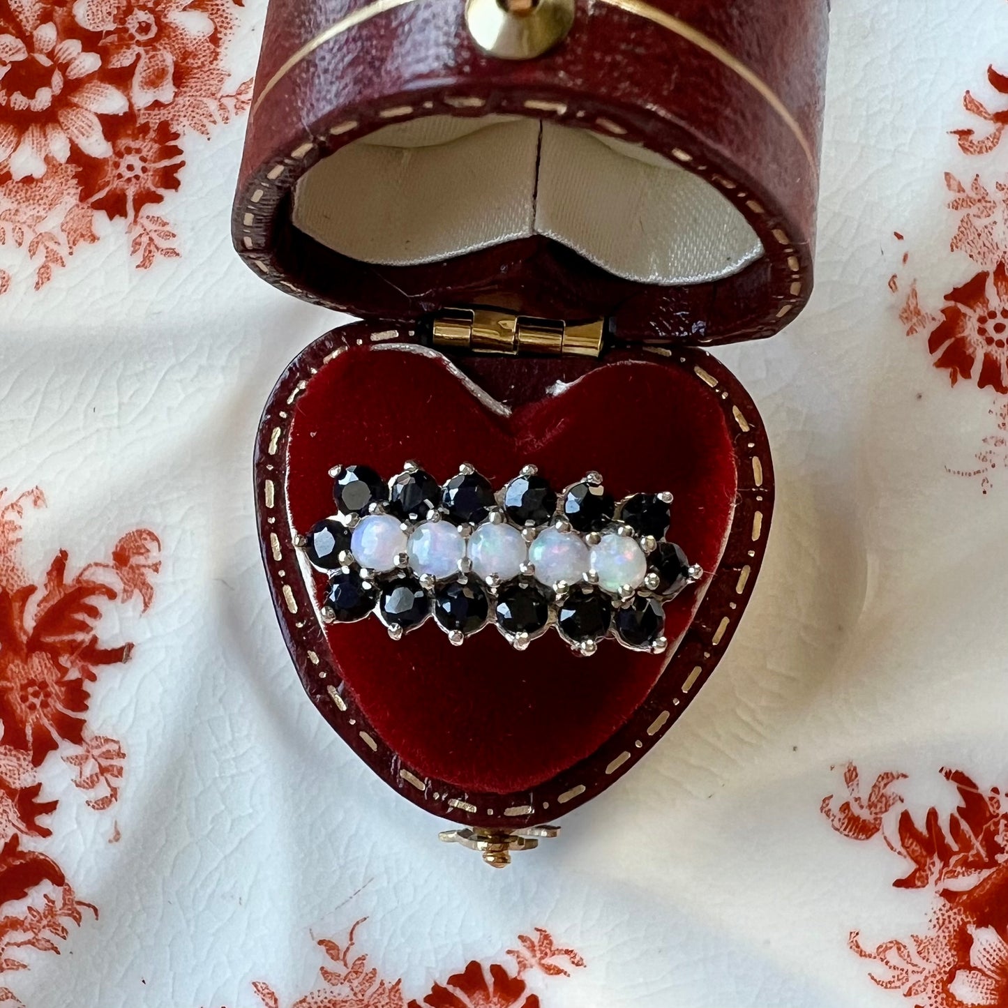 Gold ring with a band of opals surrounded by sapphires