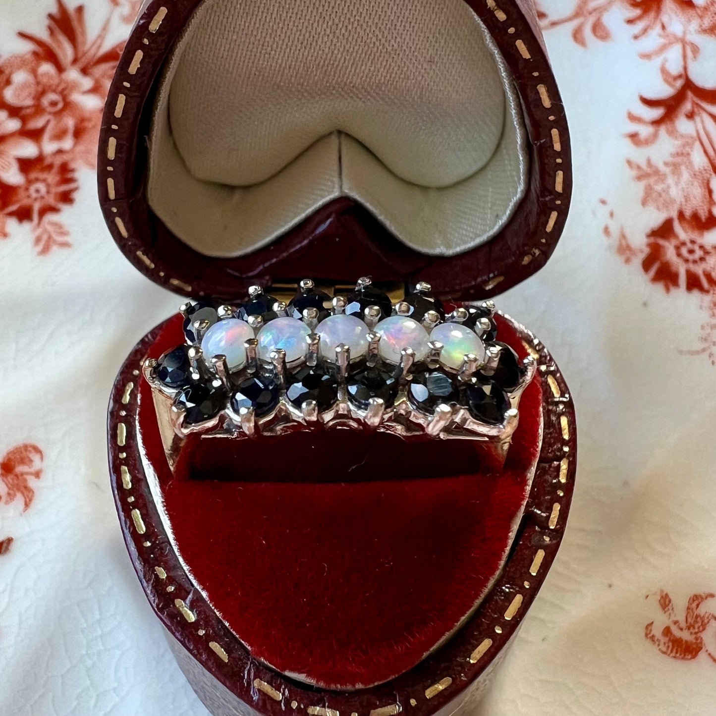 Gold ring with a band of opals surrounded by sapphires