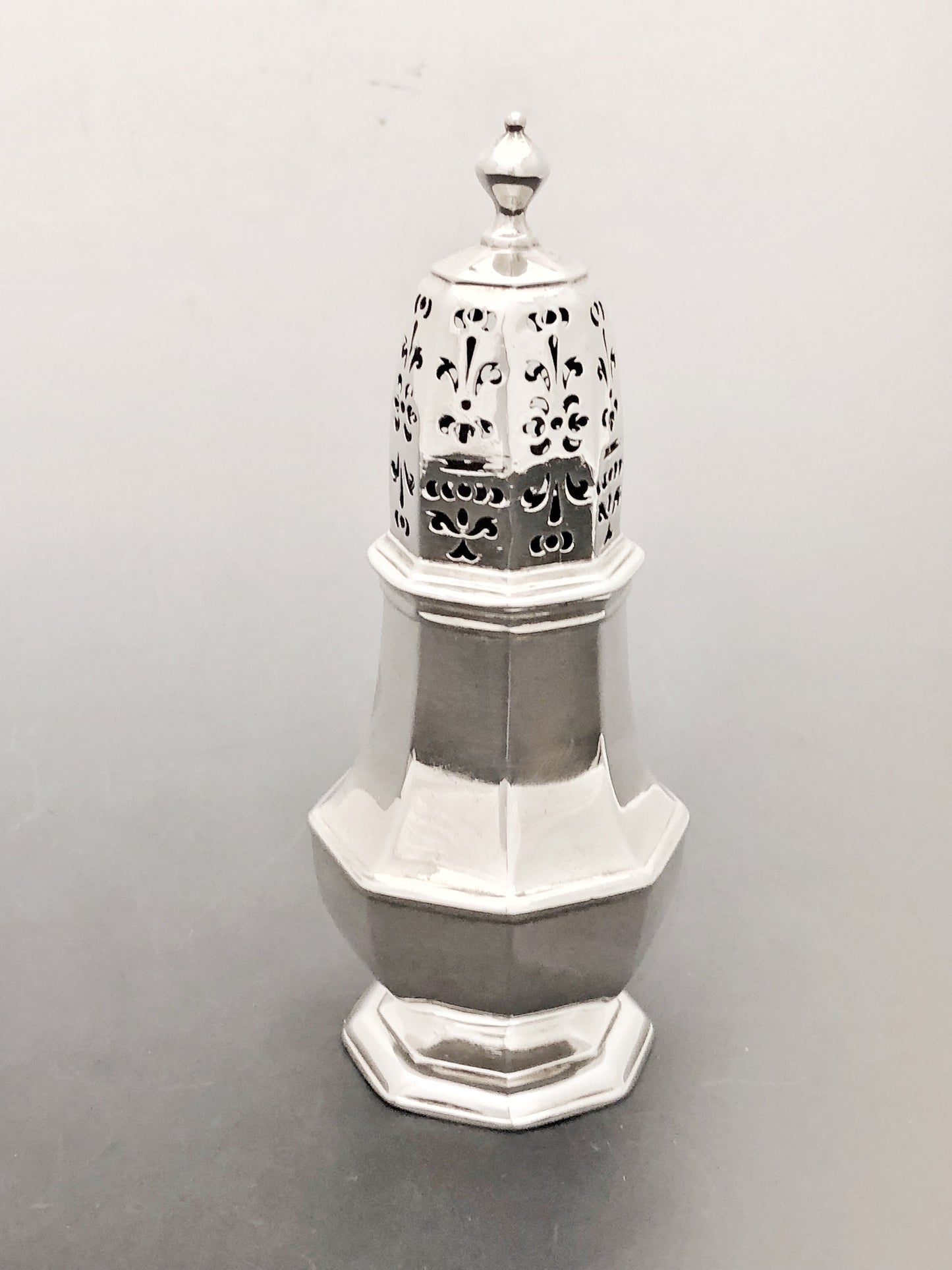 Ein äußerst seltener Zuckerstreuer aus der Zeit Georgs I., achteckig in der Form mit einem handdurchbrochenen, ineinandergreifenden Deckel. Hergestellt aus Silber in London im Jahr 1716.