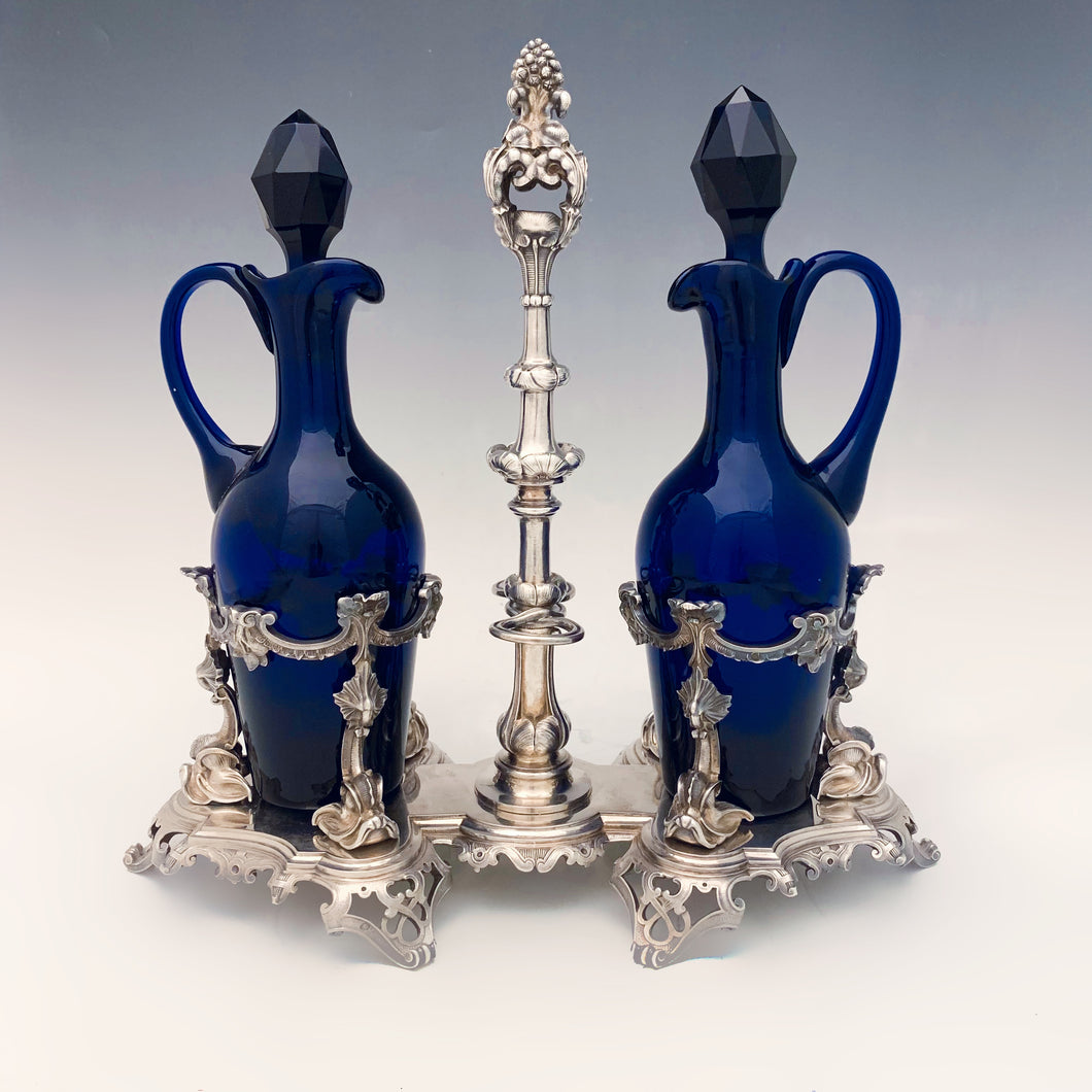 Stupenda oliera a due boccette in cristallo blu e stand in argento 950/1000 realizzata in fusione cesellata. Firmata De Marc-August Lebrun, Parigi 1819-1838.
