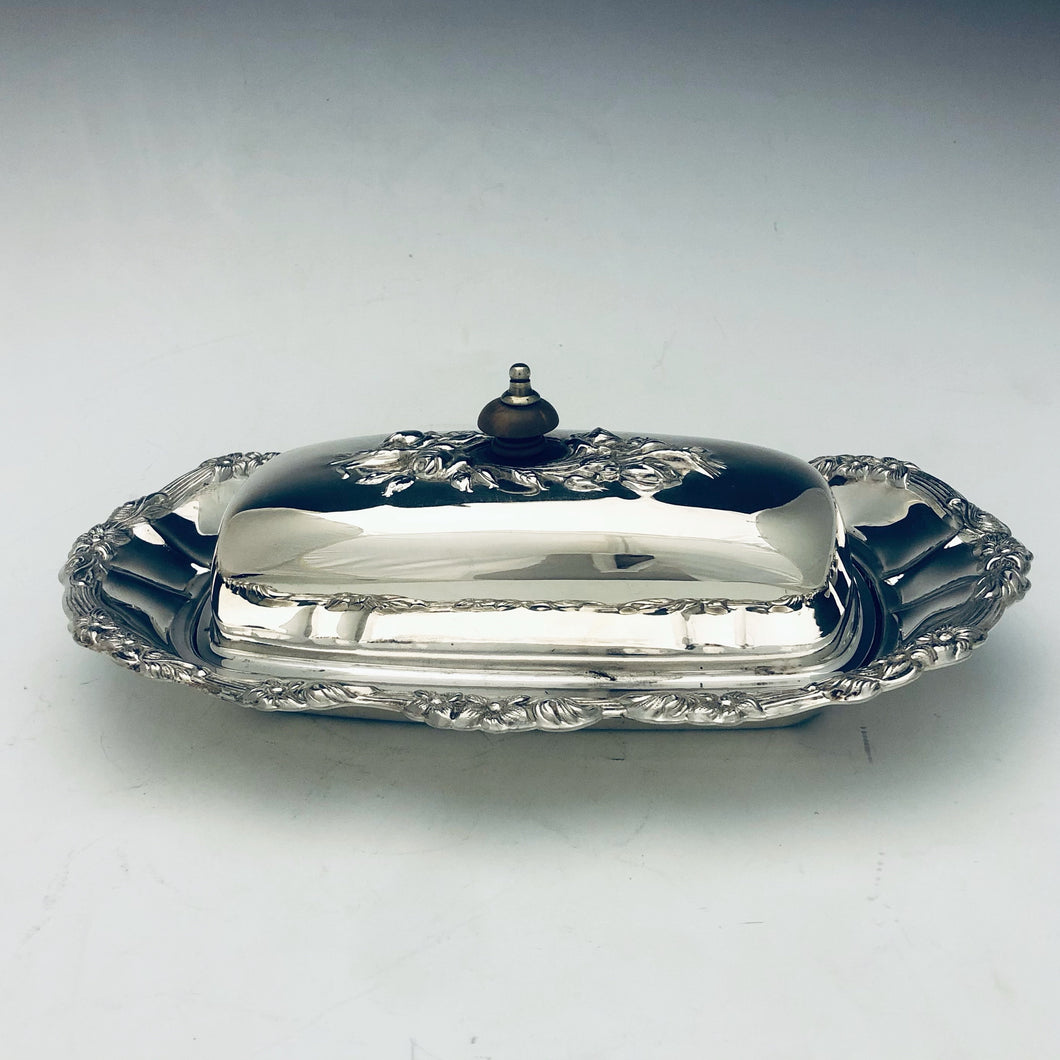 Burriera con piatto decorato all’ala e vaschetta in vetro originale all’interno. Coperchio con presa in ebano. Nord America, primi ‘900