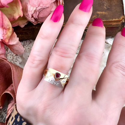 Anello chevalier “LOVE” in oro giallo 21 kt con rubino a cuore e diamanti naturali