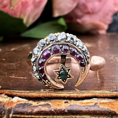 Anello vittoriano con motivi celesti. Oro rubini, diamanti e smeraldo.