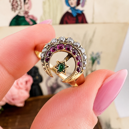 Anello vittoriano con motivi celesti. Oro rubini, diamanti e smeraldo.