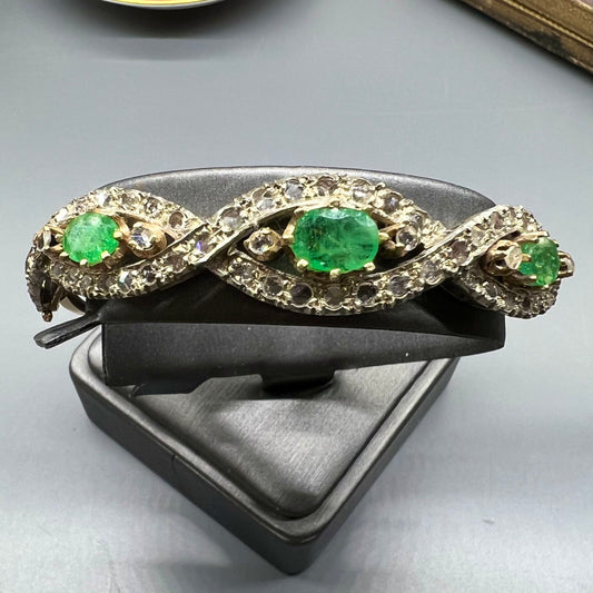 Armreif aus Gold, Smaragden und rosa Diamanten.