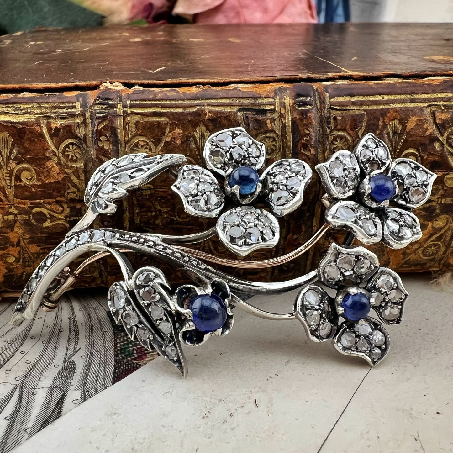 Spilla floreale in oro 18 kt, argento, zaffiri cabochon e diamanti