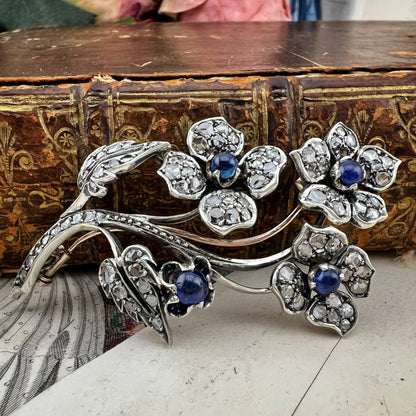 Spilla floreale in oro 18 kt, argento, zaffiri cabochon e diamanti