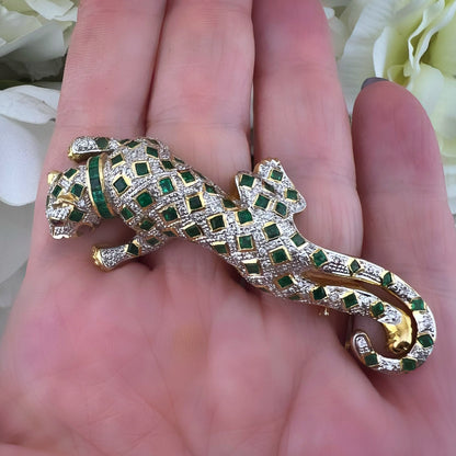Spilla animalier a forma di leopardo in oro bianco e giallo 18k con pavé di diamanti, smeraldi e rubini agli occhi. Italia c. 1960