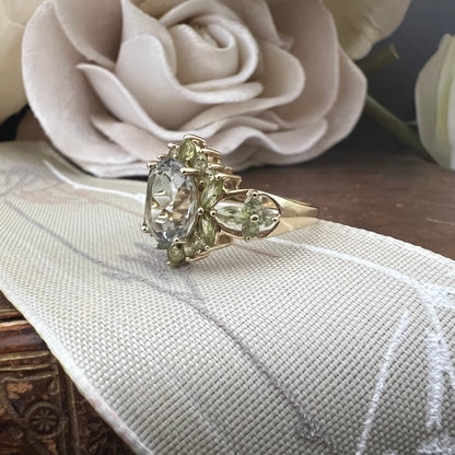 Anello con acquamarina centrale e fogliette di olivina in oro giallo