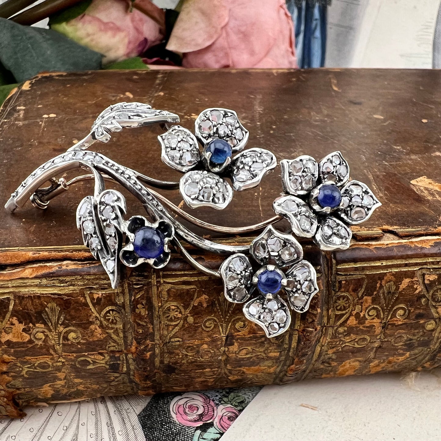 Spilla floreale in oro 18 kt, argento, zaffiri cabochon e diamanti