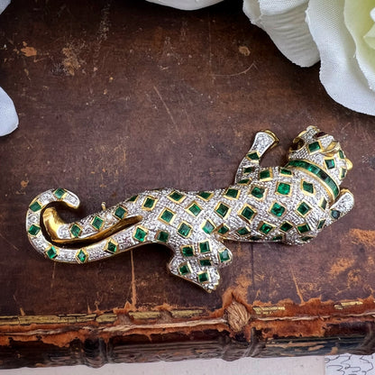Spilla animalier a forma di leopardo in oro bianco e giallo 18k con pavé di diamanti, smeraldi e rubini agli occhi. Italia c. 1960