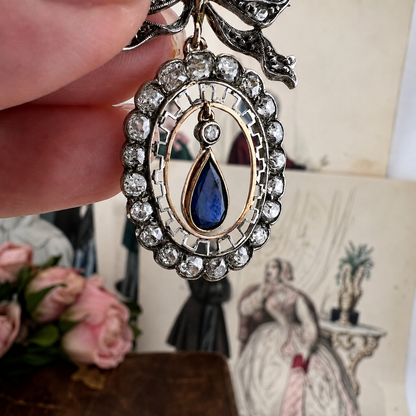 Deliziosa spilla Belle Époque in oro con fiocco, diamanti old mine e zaffiro pendente