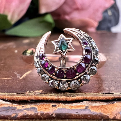 Anello vittoriano con motivi celesti. Oro rubini, diamanti e smeraldo.