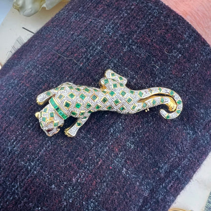 Spilla animalier a forma di leopardo in oro bianco e giallo 18k con pavé di diamanti, smeraldi e rubini agli occhi. Italia c. 1960