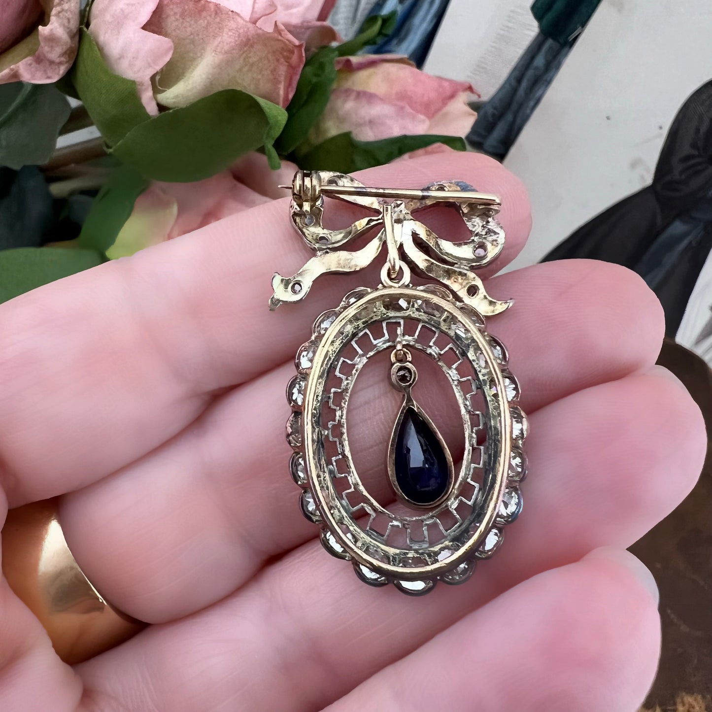 Deliziosa spilla Belle Époque in oro con fiocco, diamanti old mine e zaffiro pendente
