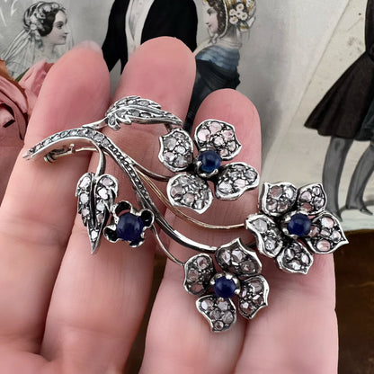 Spilla floreale in oro 18 kt, argento, zaffiri cabochon e diamanti