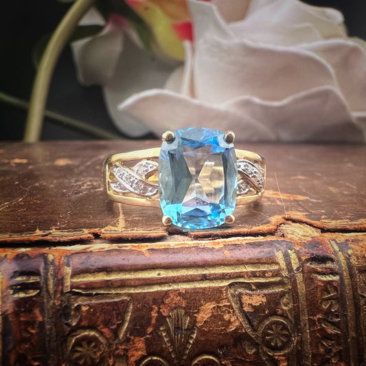 Anello con topazio azzurro e spallette a giorno con diamanti