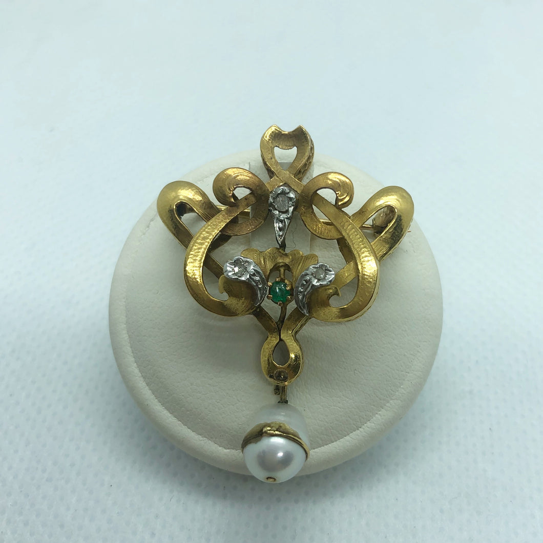 Spilla primi ‘900 in oro 18 carati di provenienza italiana con tre rosette di diamanti, uno smeraldo ed una perla
