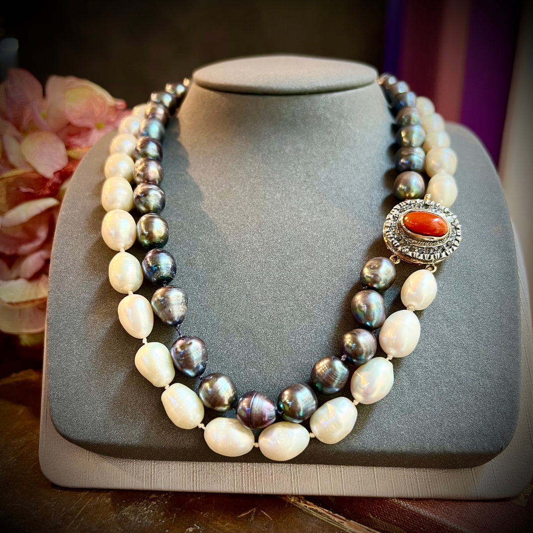 Collana vintage con un filo di perle scaramazze nere e uno bianco. Chiusura in oro, corallo e rosette di diamanti