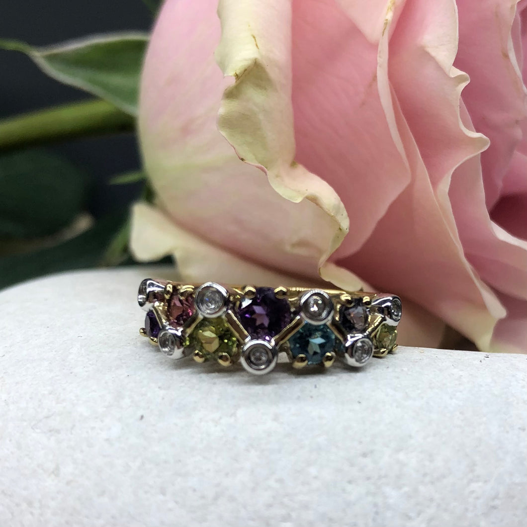 Anello vintage dal design intrigante con diamanti, tormalina rosa, topazio azzurro, iolite, peridoto e ametista